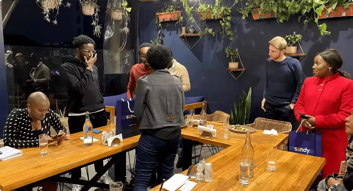 The Sendy team gathered around a table at a launch event.
